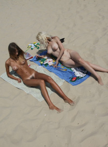 Naked teens rest on the beach